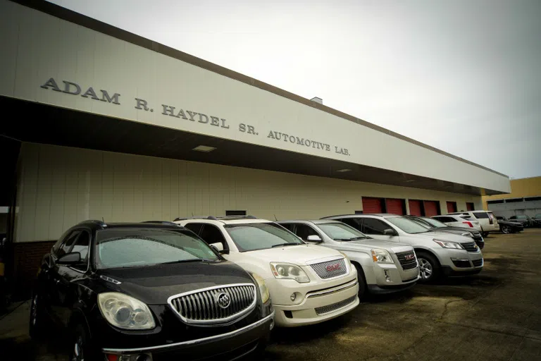 multiple cars of different colors lined up in front of a building