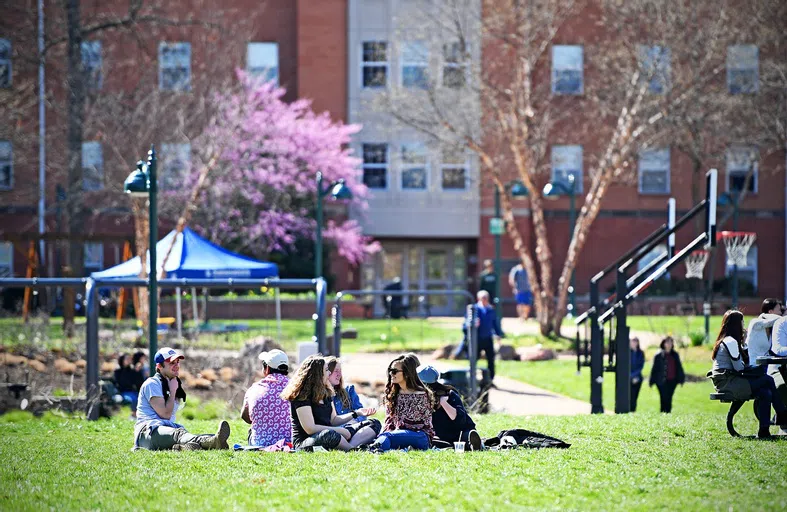 Students sit in the grass on the South 40