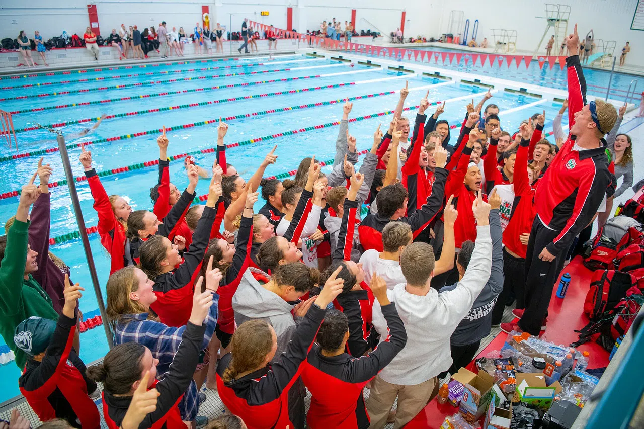 Students cheer on the WashU Swim Team at the pool