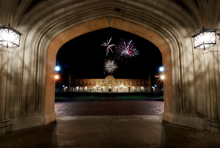 Fireworks exploding over Holmes Lounge, seen through the Brookings Archway