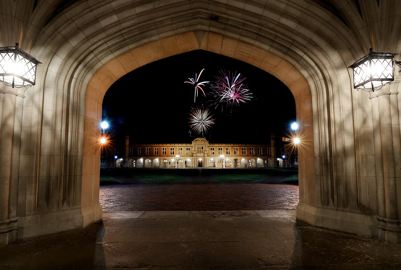 Fireworks exploding over Holmes Lounge, seen through the Brookings Archway