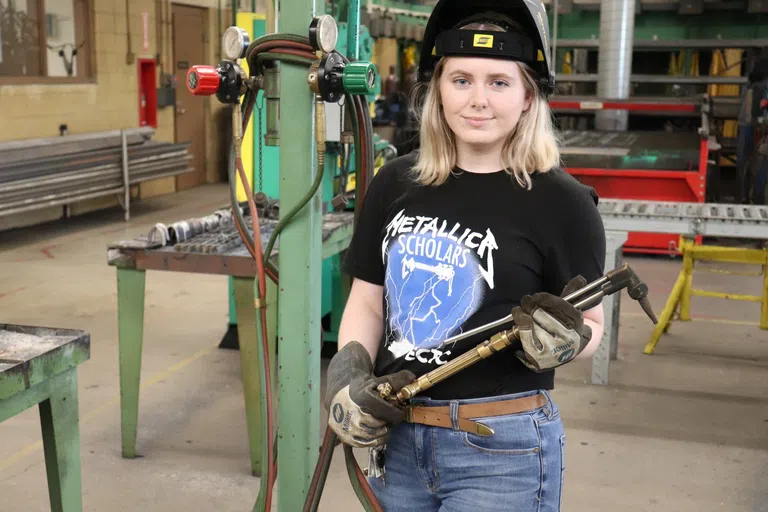 Student holding welding torch.