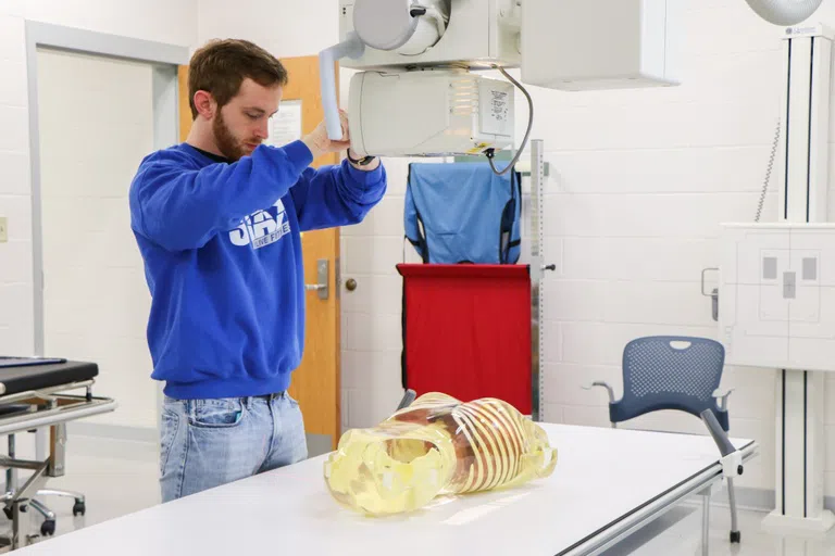 Radiography students prepares for an x-ray. 