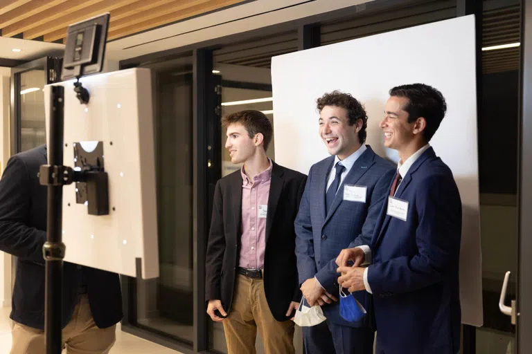 Three male guests at a photo booth during Hillel's opening reception