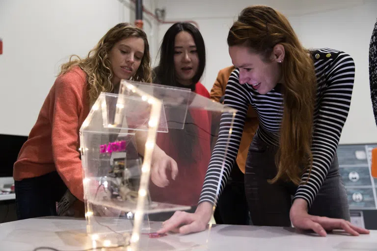 Three students working on an interaction 3D design project.