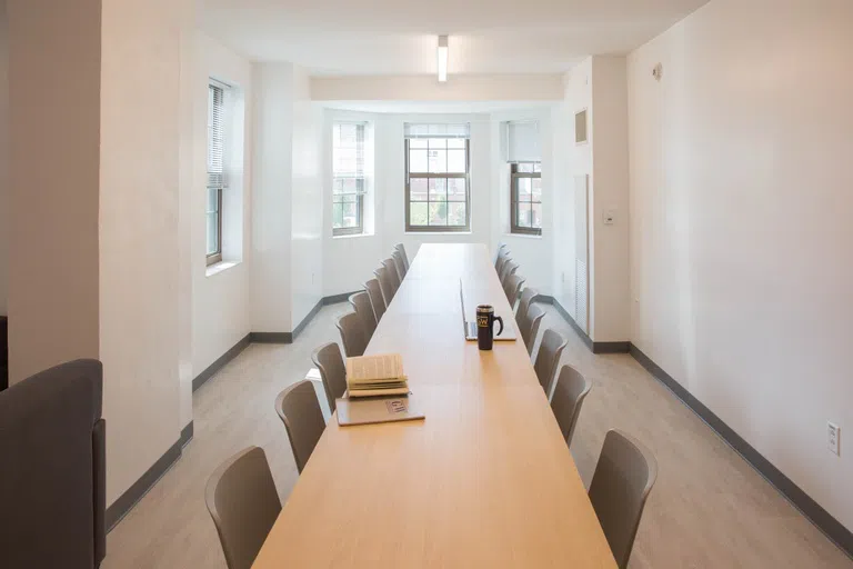 Meeting room with long table and chairs.