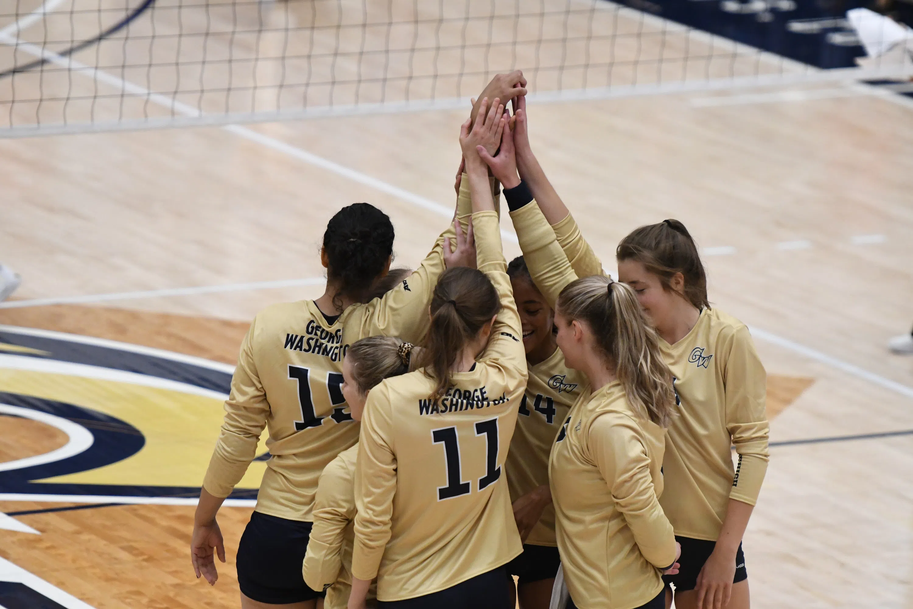 Women's volleyball players standing in a circle