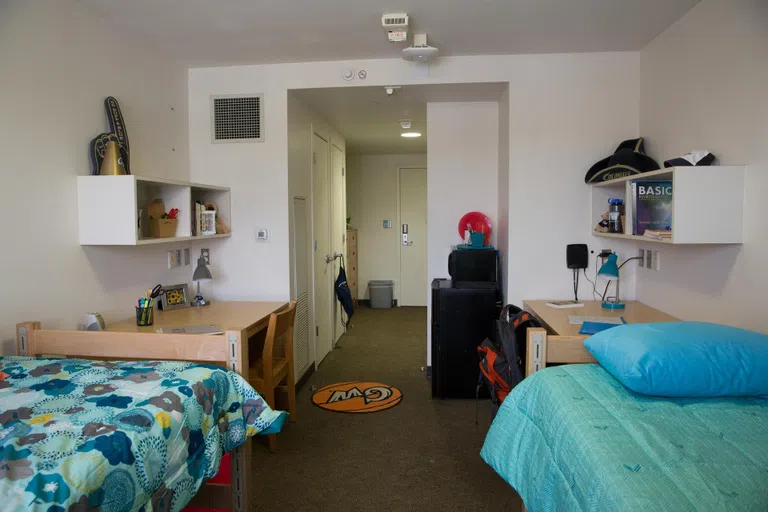 A typical room in Potomac Hall, with 2 twin beds, desks and chairs, dressers, closet, and a micro fridge.