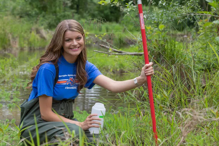 Student gathers samples from the Paris Lake Wetlands