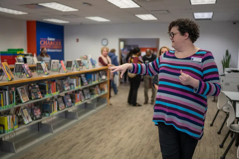 Staff member shows rows of books in the Learning Commons