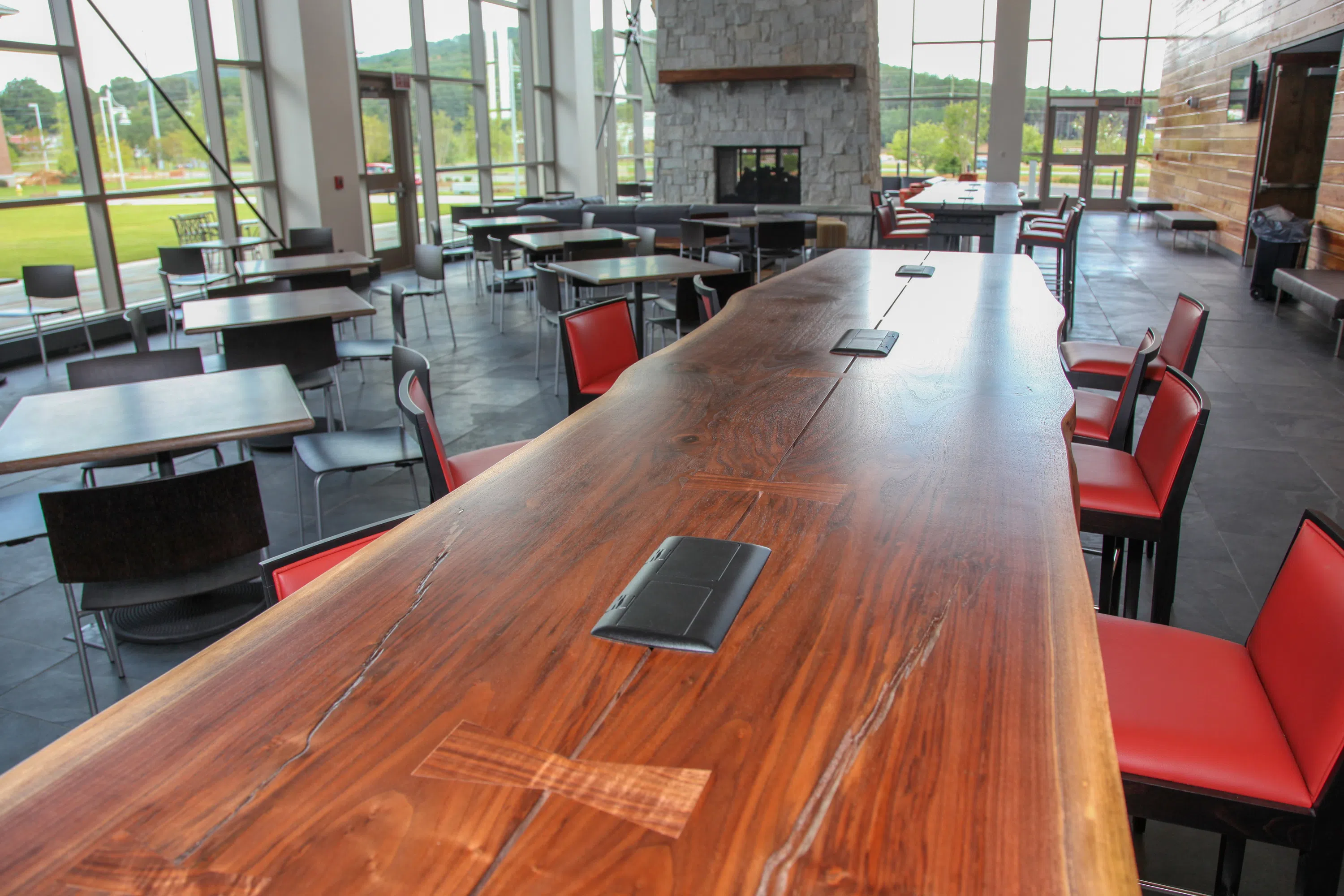 Close up of a long table with chairs placed around it in the common area