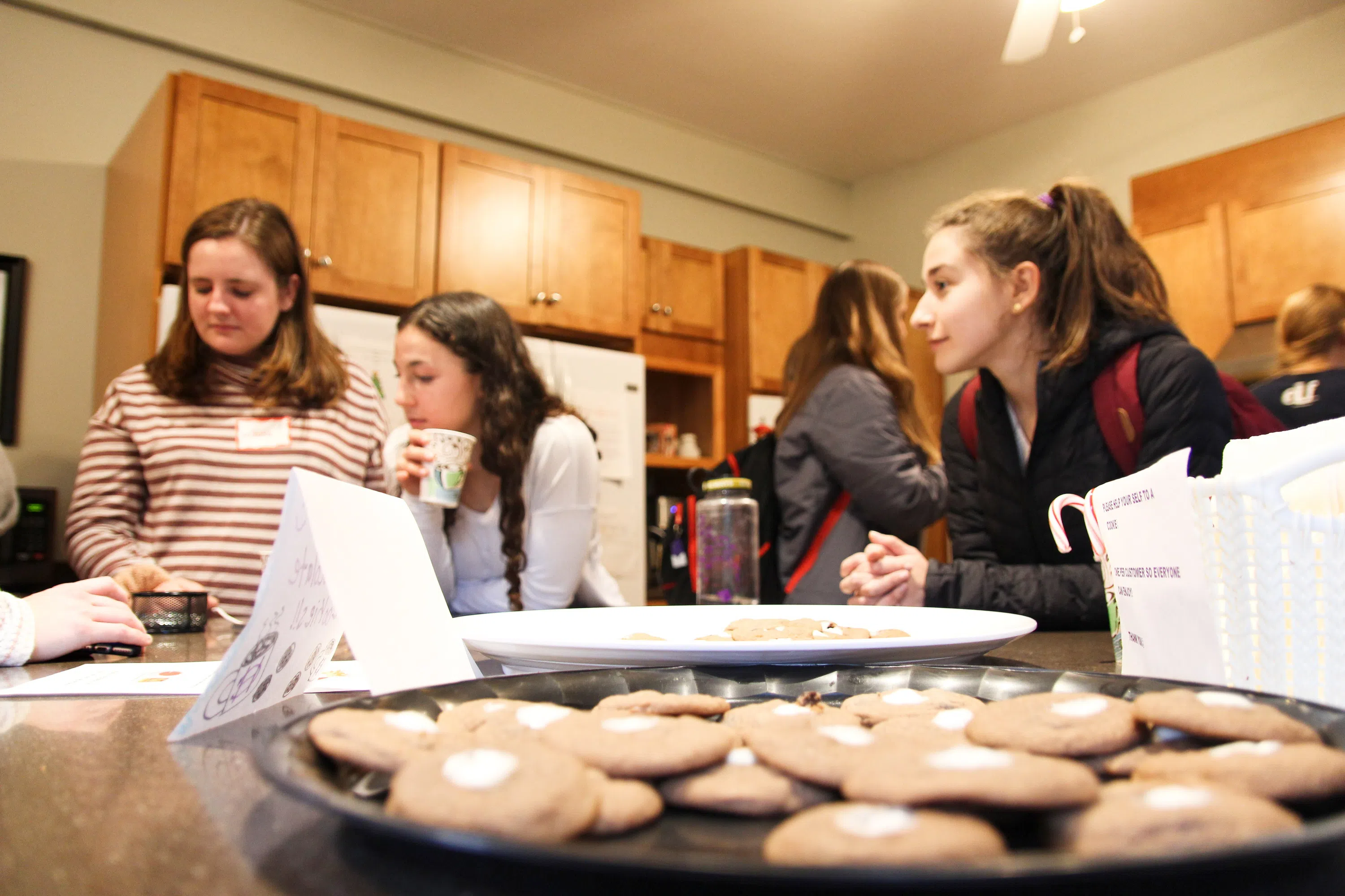 Students hang out in kitchen baking cookies.
