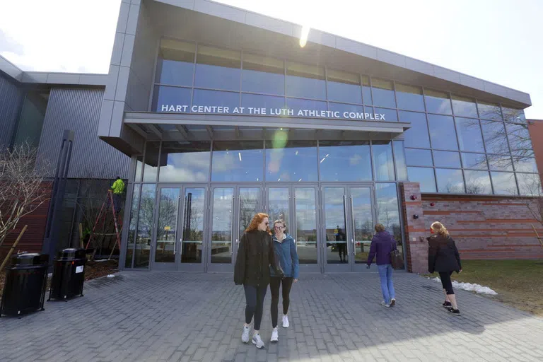 Students stand in front of the main athletics facility