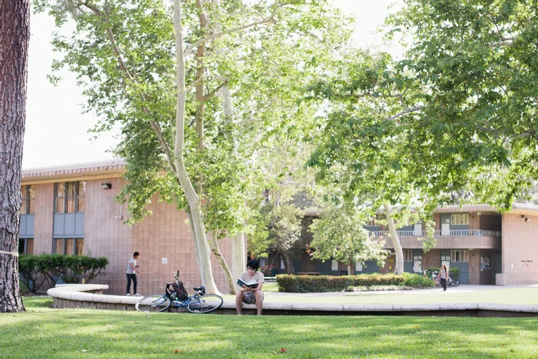 Student reading in front of dorm