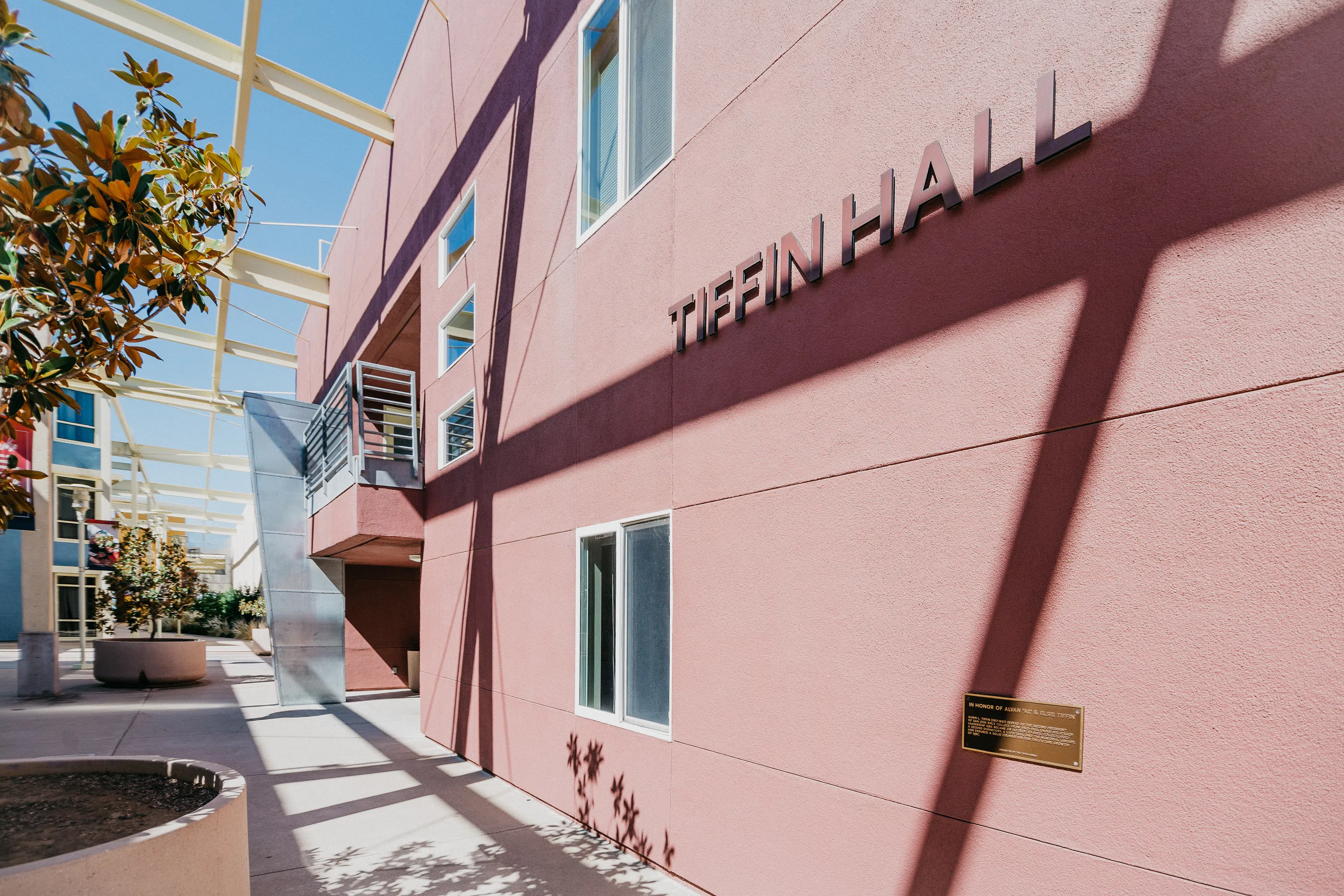 Exterior of Tiffin Hall with pink walls and trees