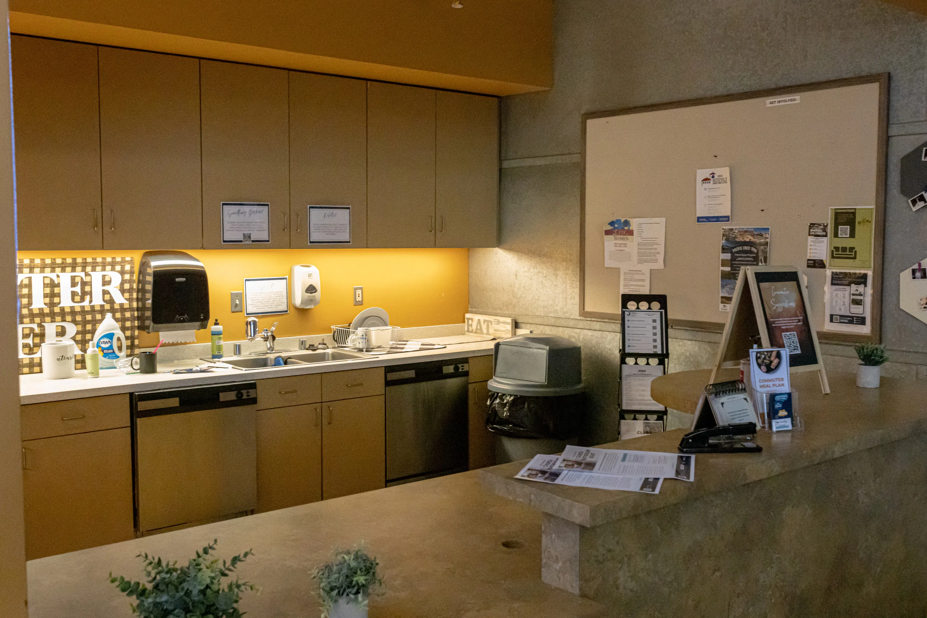 Commuter kitchen with full sink, plenty of storage, and a bulletin board