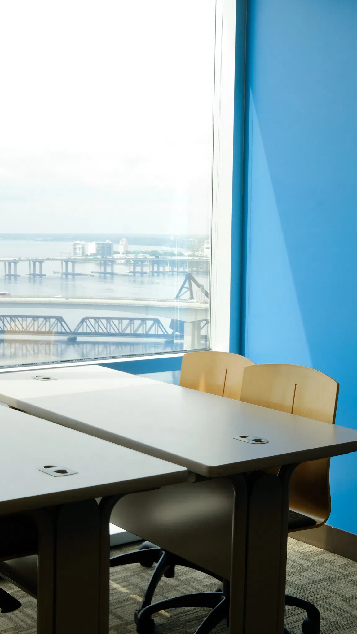 A table with four chairs positioned in front of a window with a view of the St. John's River.