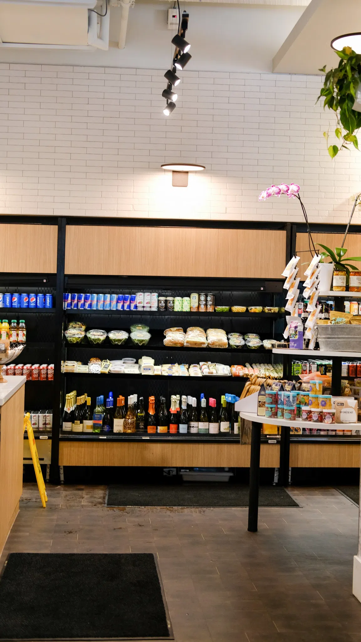 A refrigerated wall with quick, takeaway food options, energy drinks, alcoholic beverages, and desserts.