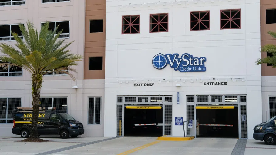 A white main entrance of a parking garage, with both an "enter" and "exit" side.