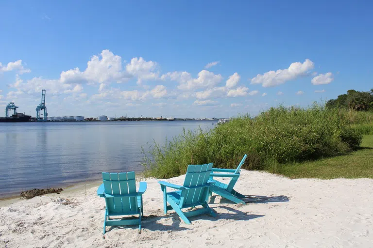 Picture of Adirondack chairs down by the beach.