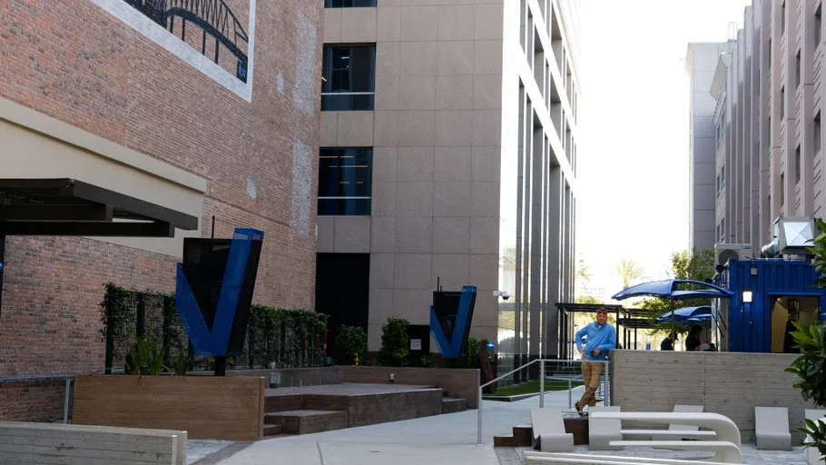 A landscape view of a breezeway positioned in between the Vystar Tower and Vystar bank, where there is a food truck.