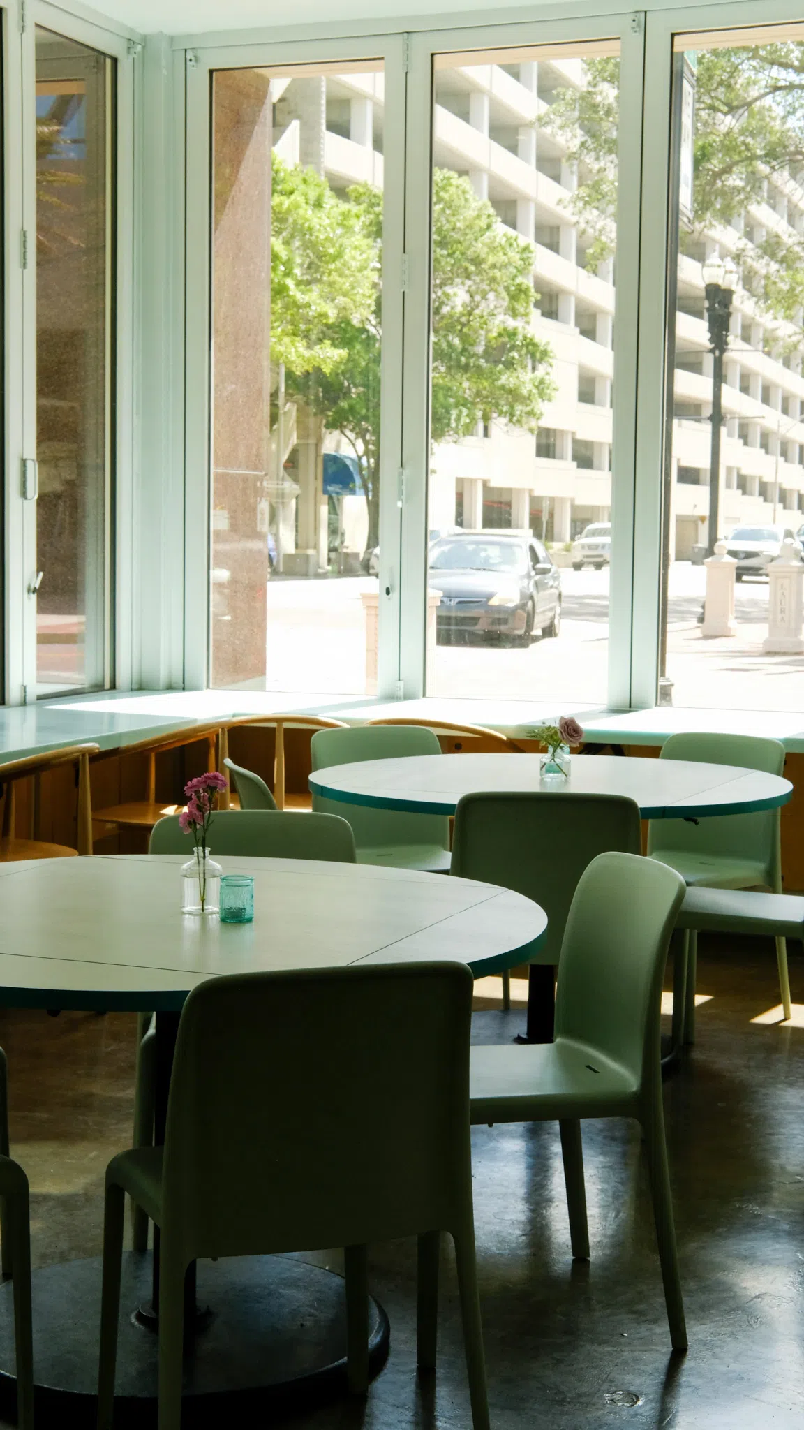 Large white dining tables arranged in a room surrounded by windows with a view of the streets of downtown Jacksonville.