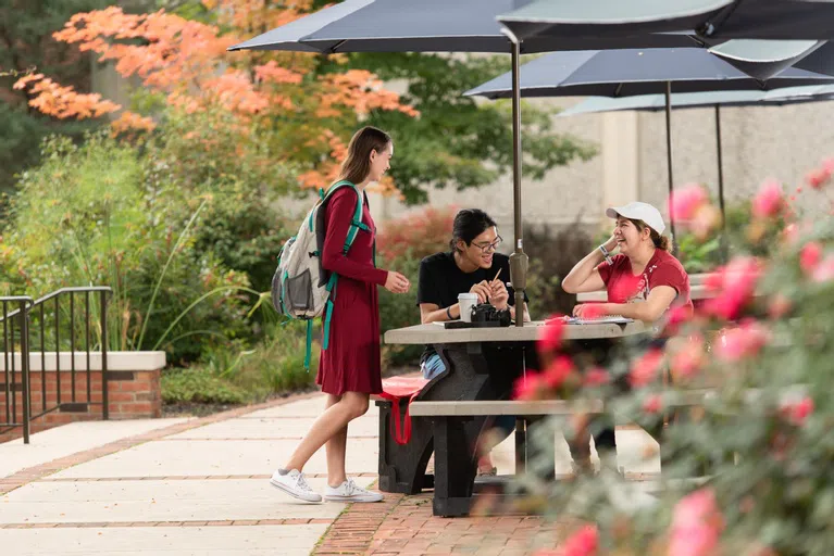 Students at Penny's Plaza, the outdoor sitting area outside of the AC.