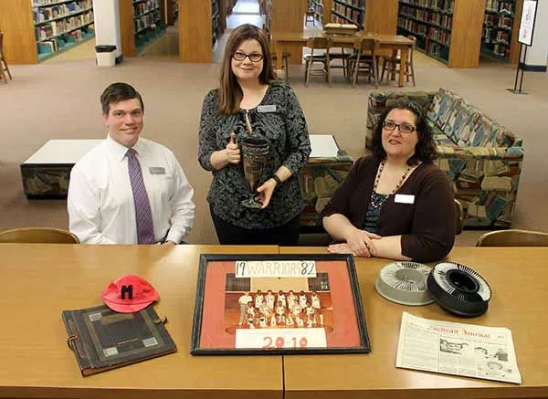 Members of the MGA Library archival team along with a few of the items they will be working to preserve, catalog, and, in some cases, display.