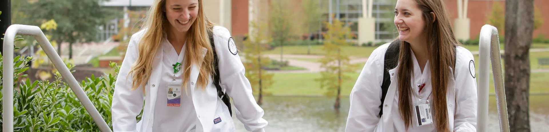 Two nursing students walk up a staircase.