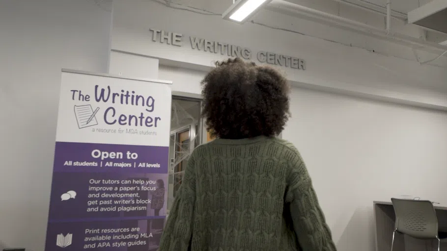 Person reads sign outside of the Writing Center.