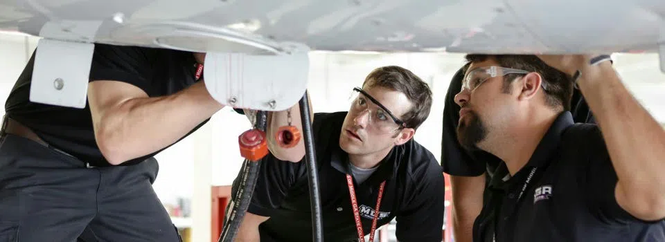 Student mechanics work on an airplane.
