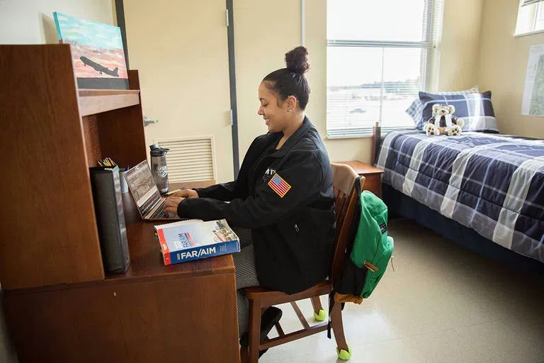 Student works on homework in dorm room.