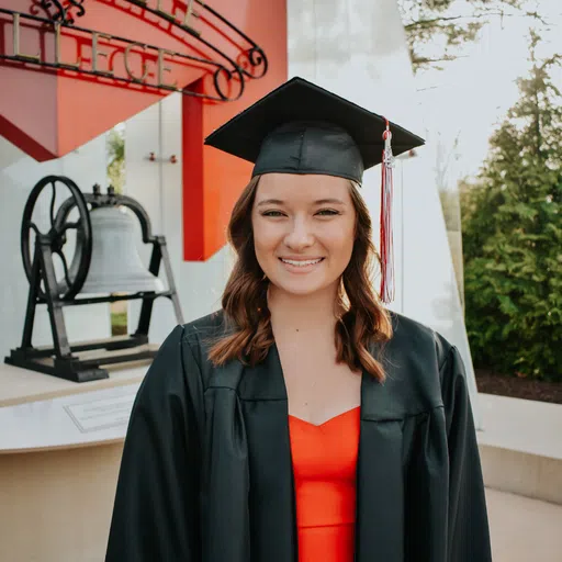 A student stands in front of the Maryville Bell