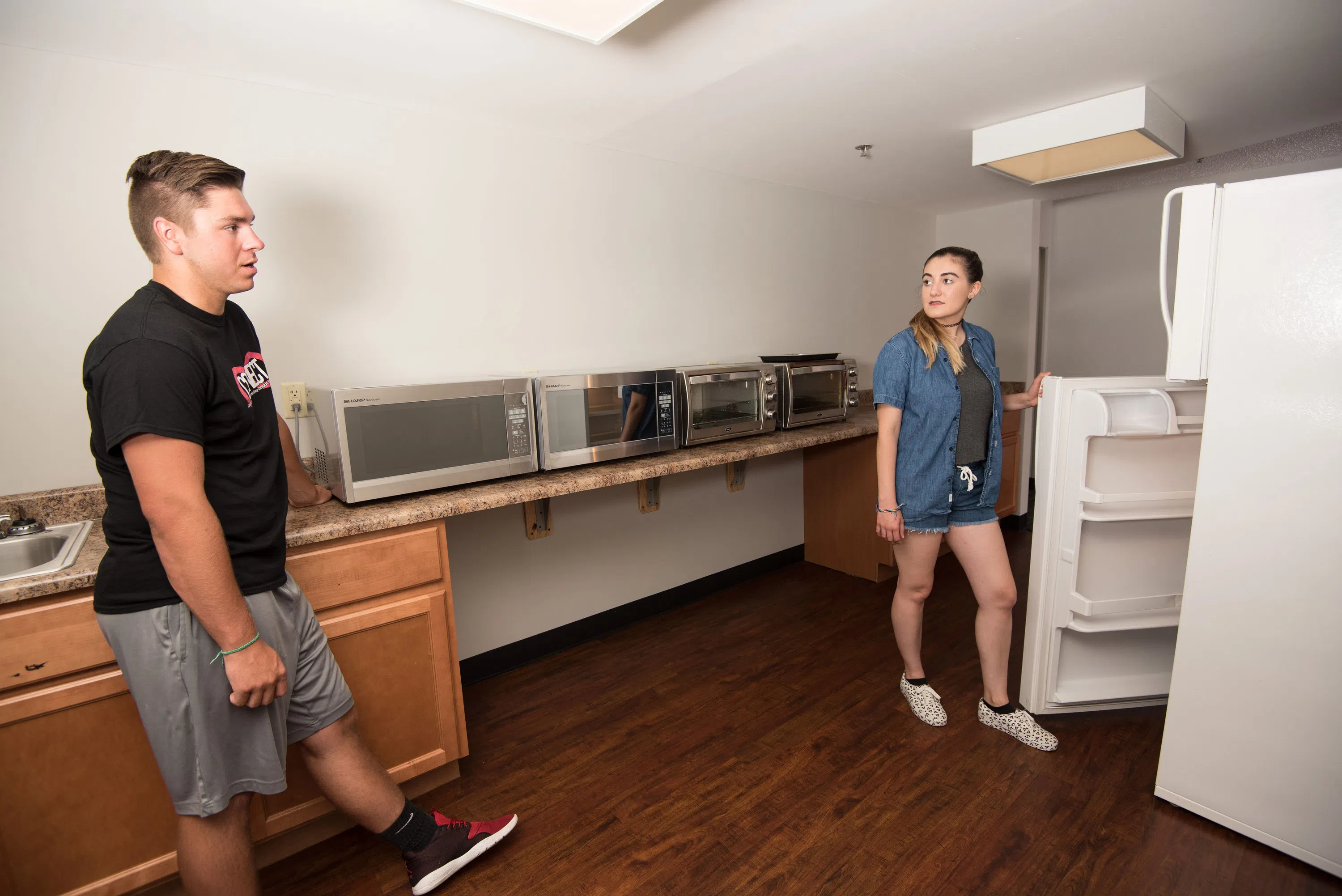 Students access a refridgerator, microwave, and toaster oven in one of the kitchenettes in Potter Hall. 