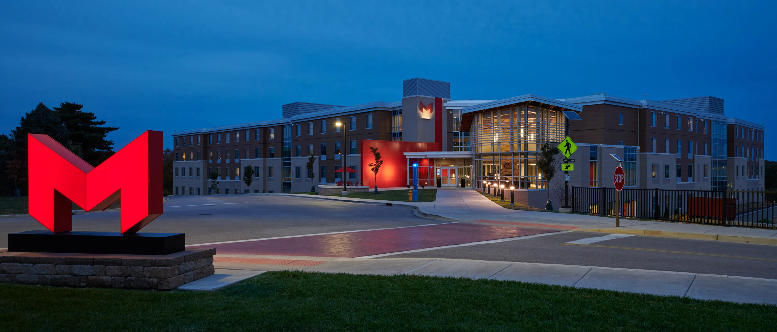 Saints Hall exterior (night) with glowing "Big Red M."