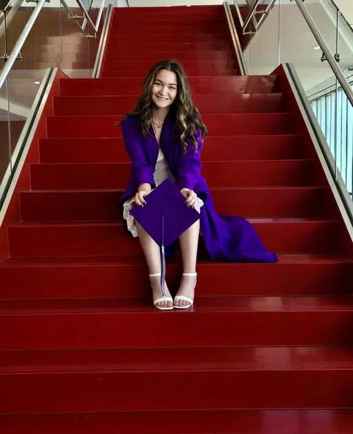 A future Saint stops by campus to get a grad picture on the iconic red steps.