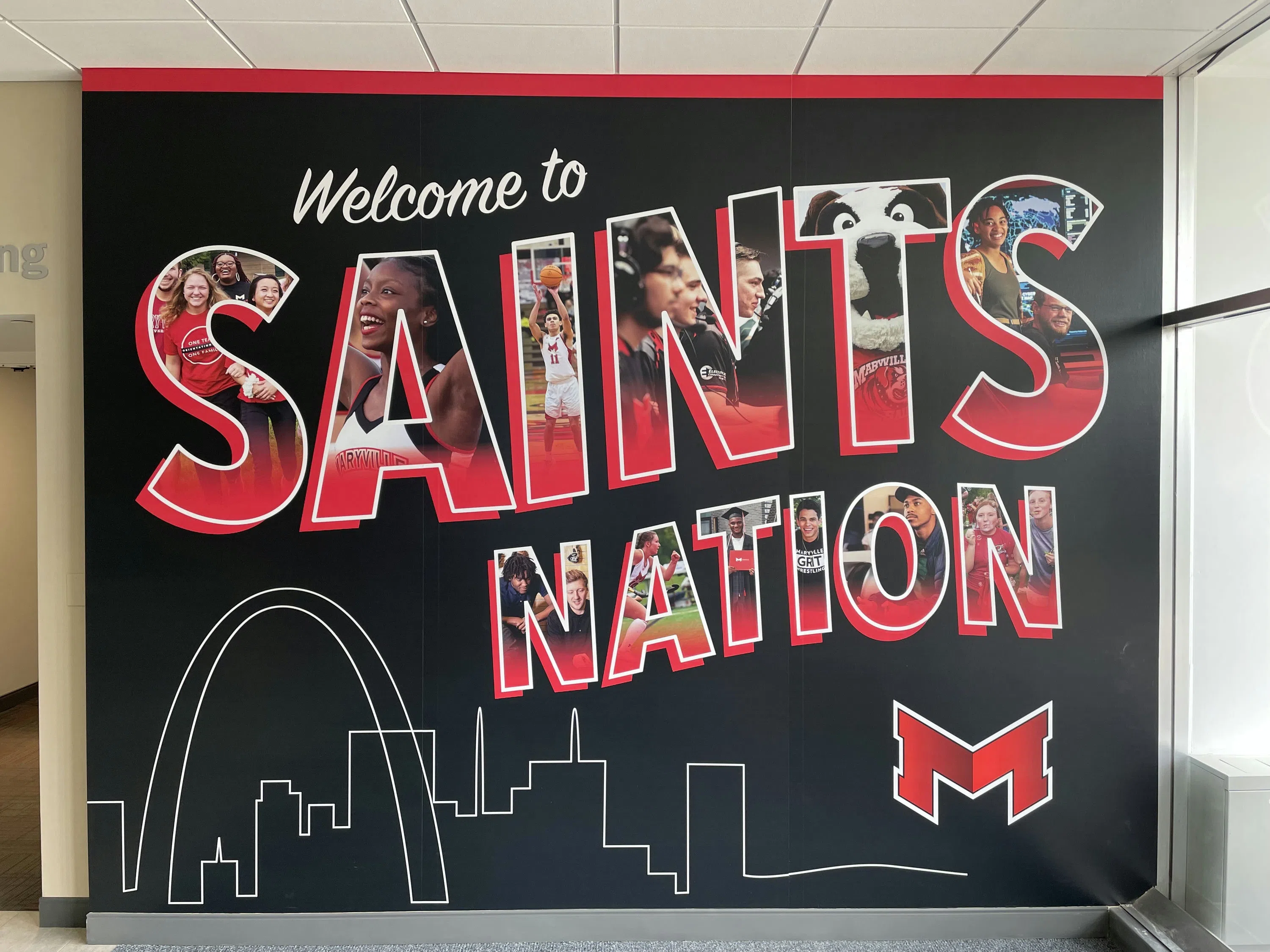 "Welcome to Saints Nation" written on the wall. Each letter has photos of campus life in them.