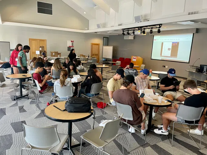 Students set up their iPads in Buder Commons during international student orientation week. 