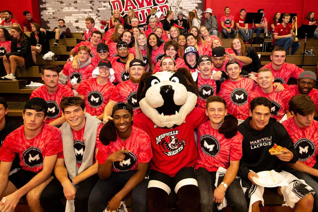 Students spend time with Louie in The Dawg Pound at a basketball game. 