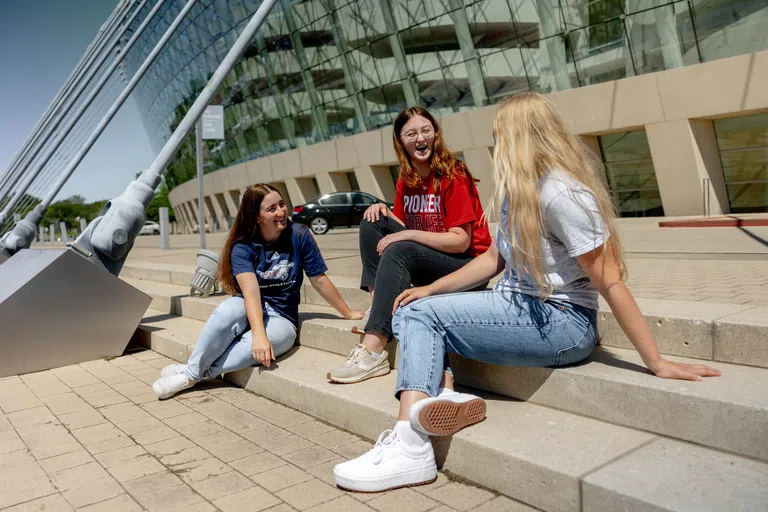 Students sit on the steps outside of the Kauffman Performing Arts Center