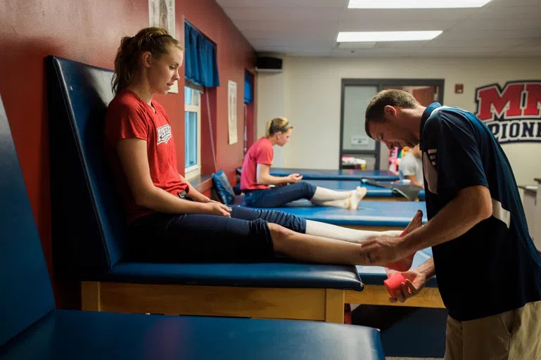 Athletic trainer treats athlete