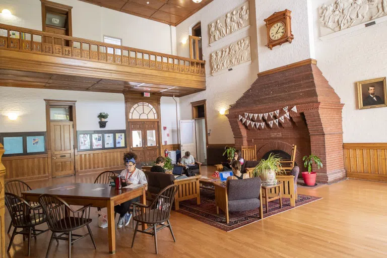 Students studying inside Peters Hall near the fireplace