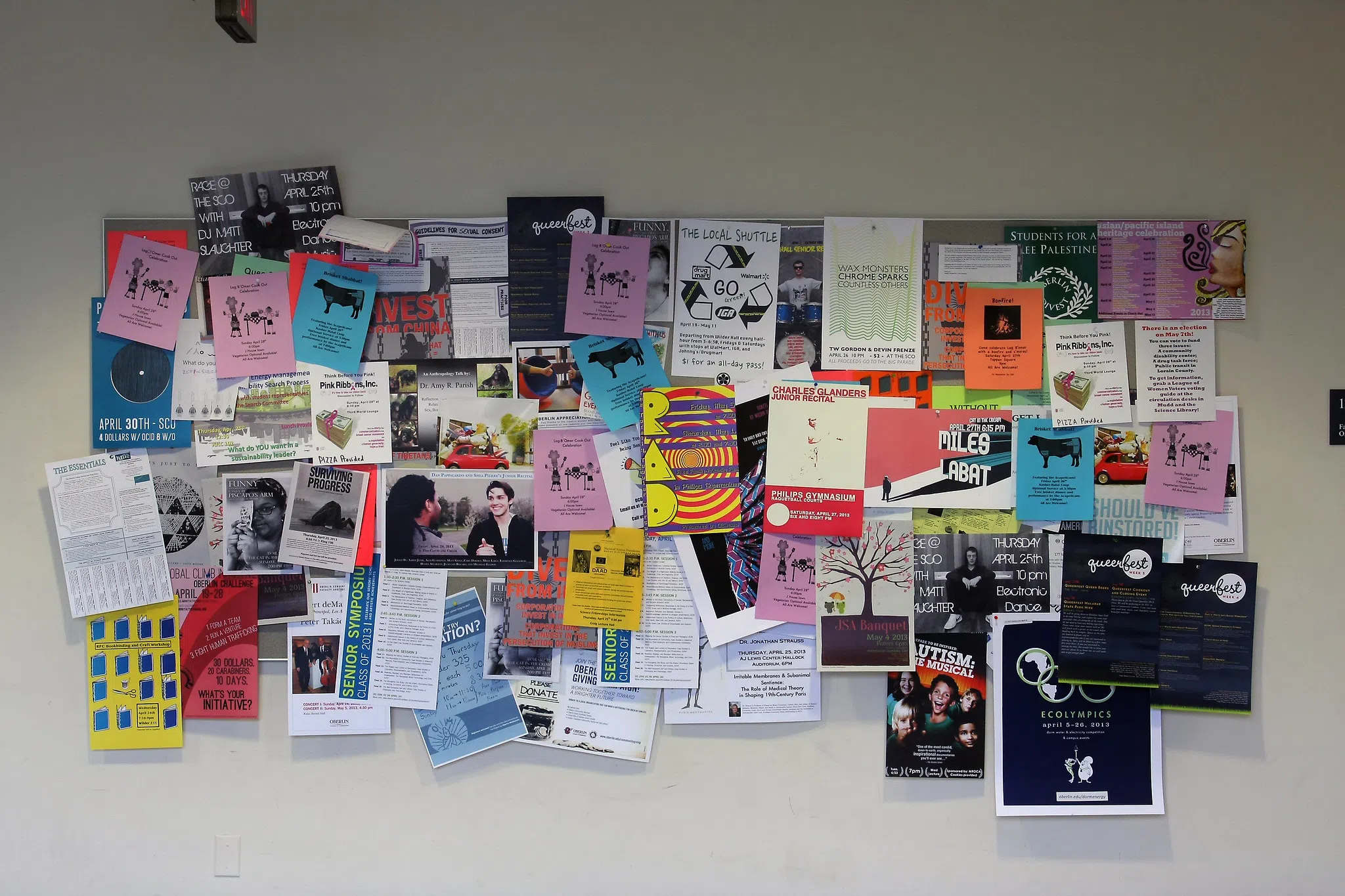 A bulletin board of colorful posters is overflowing with activities, events, author talks, grad school info, and shows.