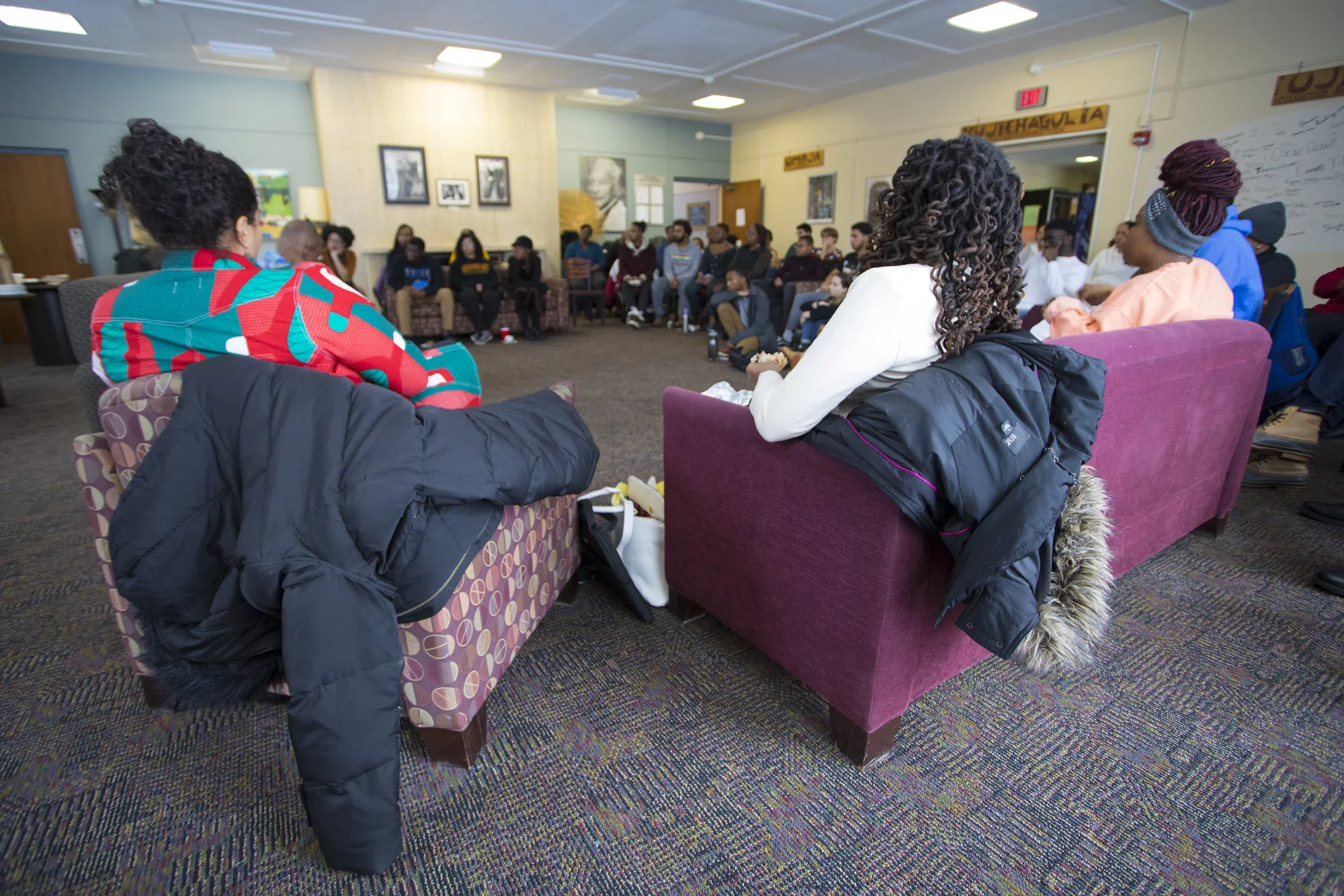 Students listen to a guest speaker in the lounge of Lord-Saunders (Afrikan Heritage House)