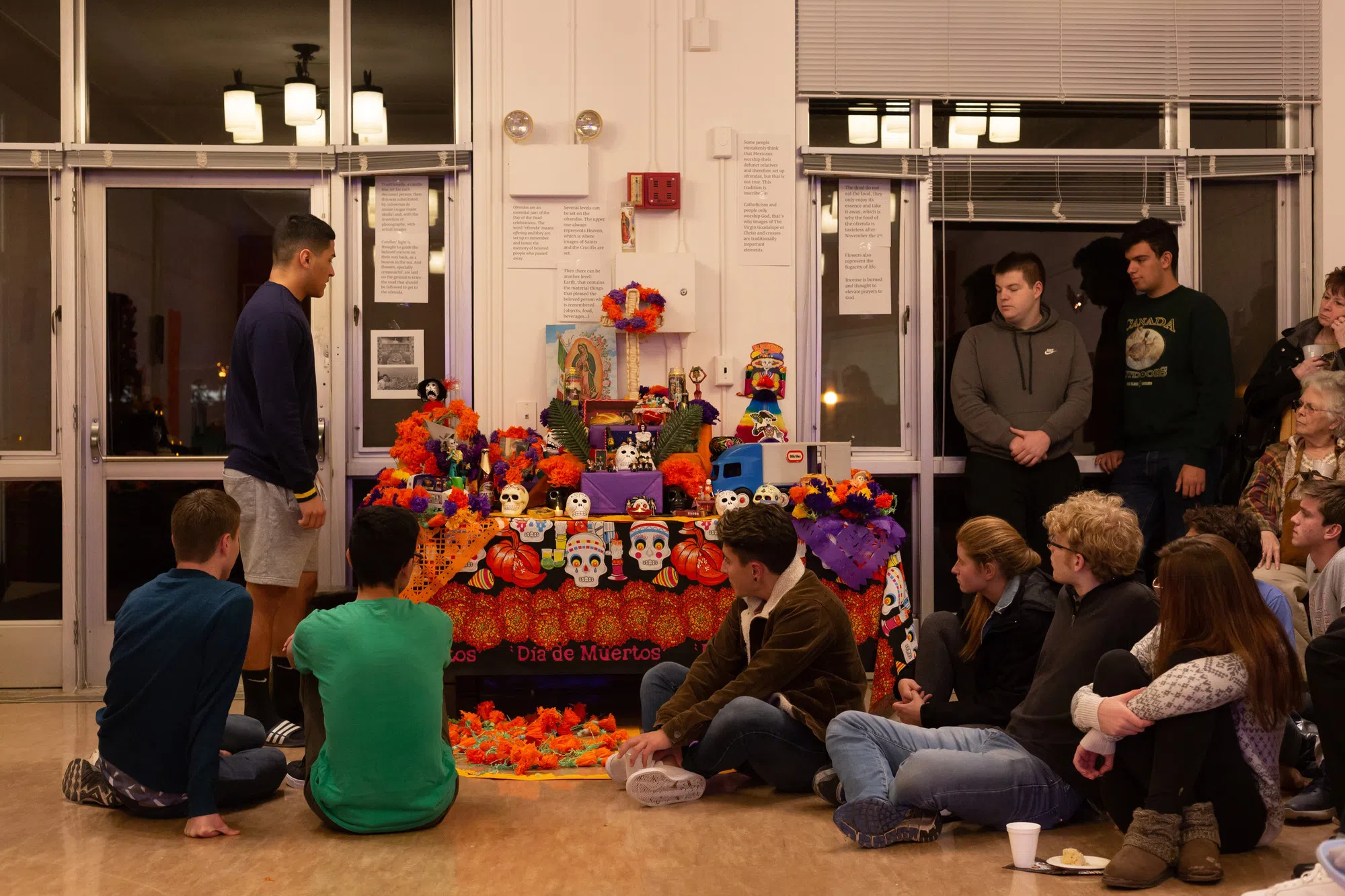 Students surround a commemorative altar for Dia de los Muertos