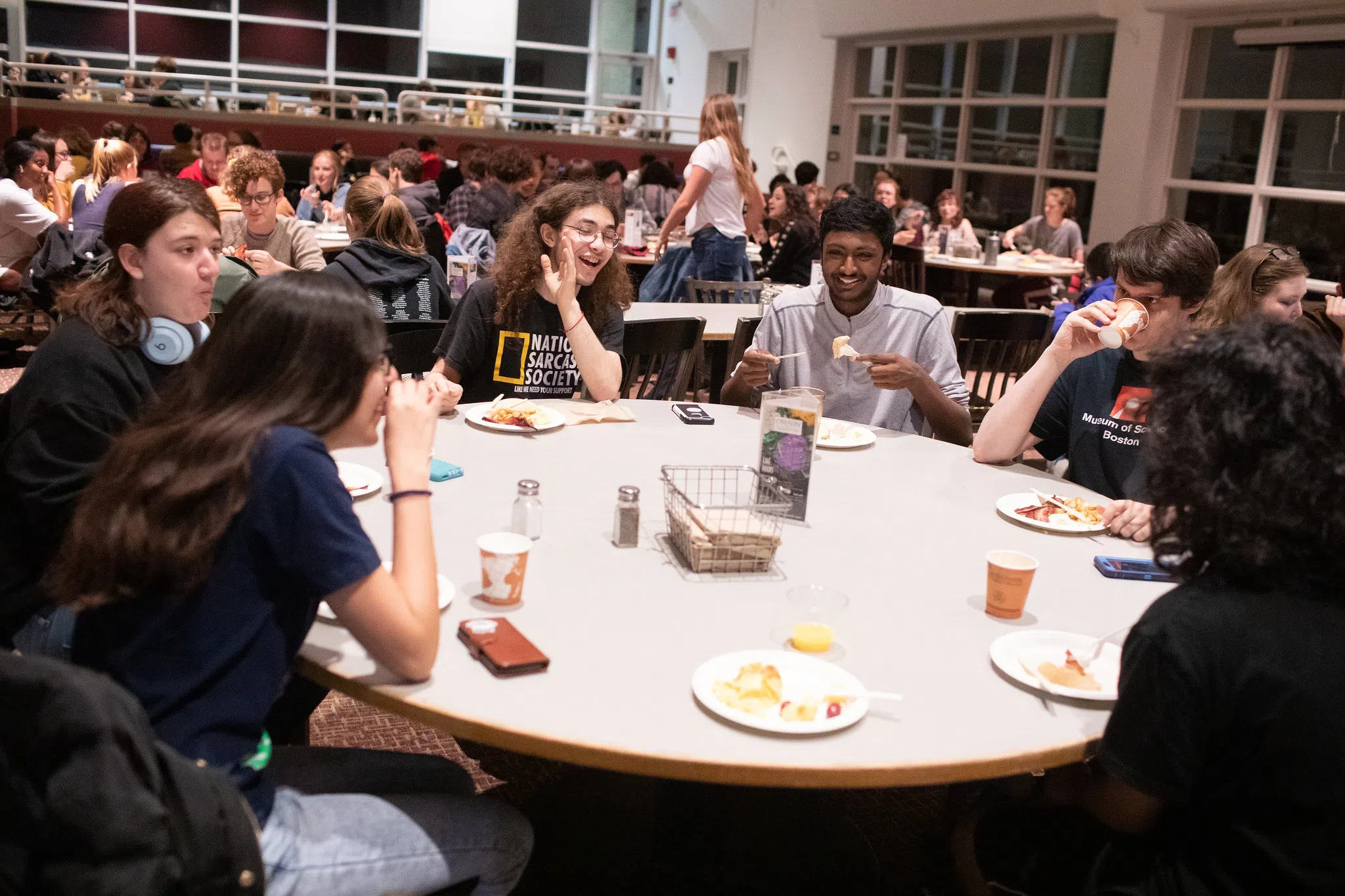 Students laugh and enjoy their meal at a table in Stevenson dining hall.