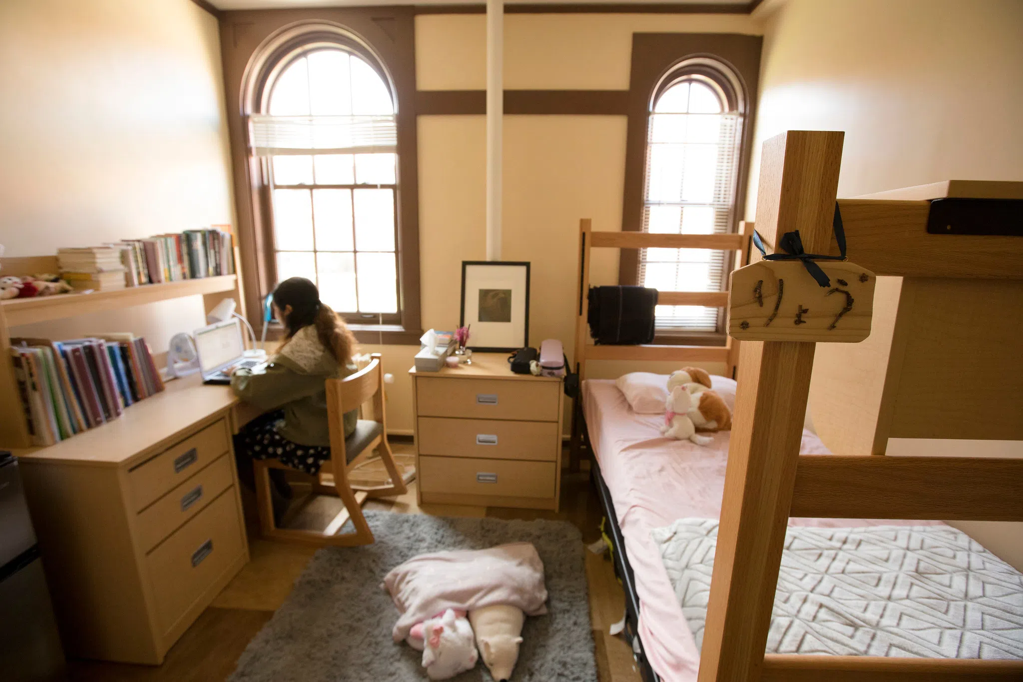 A student sits at her desk in her Asia House dorm room