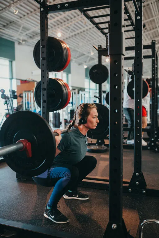 Student using squat rack in the Noble Center​