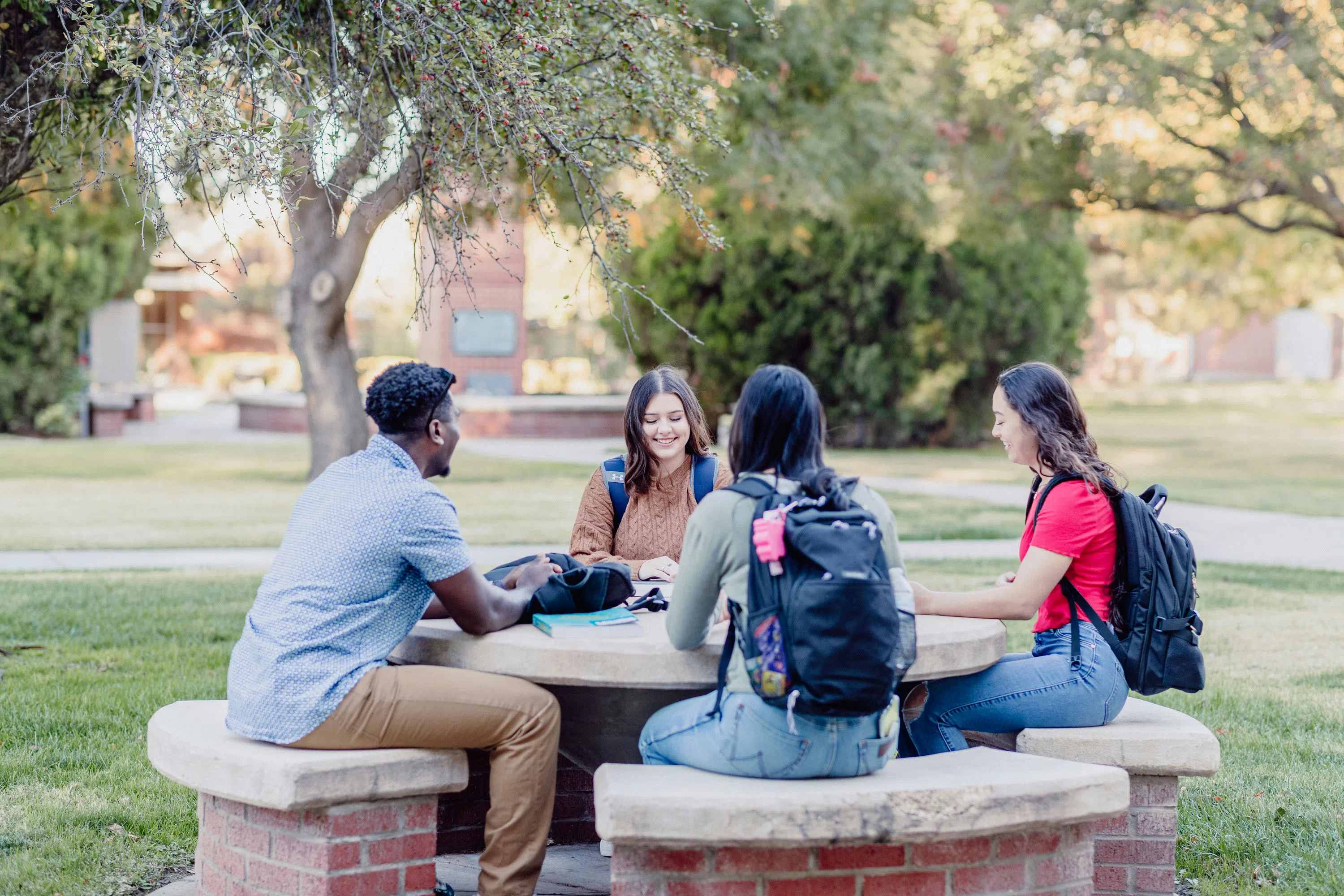 Students sitting at a table in the plaza