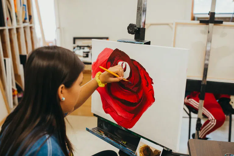 Student painting a rose in Hesper Hall